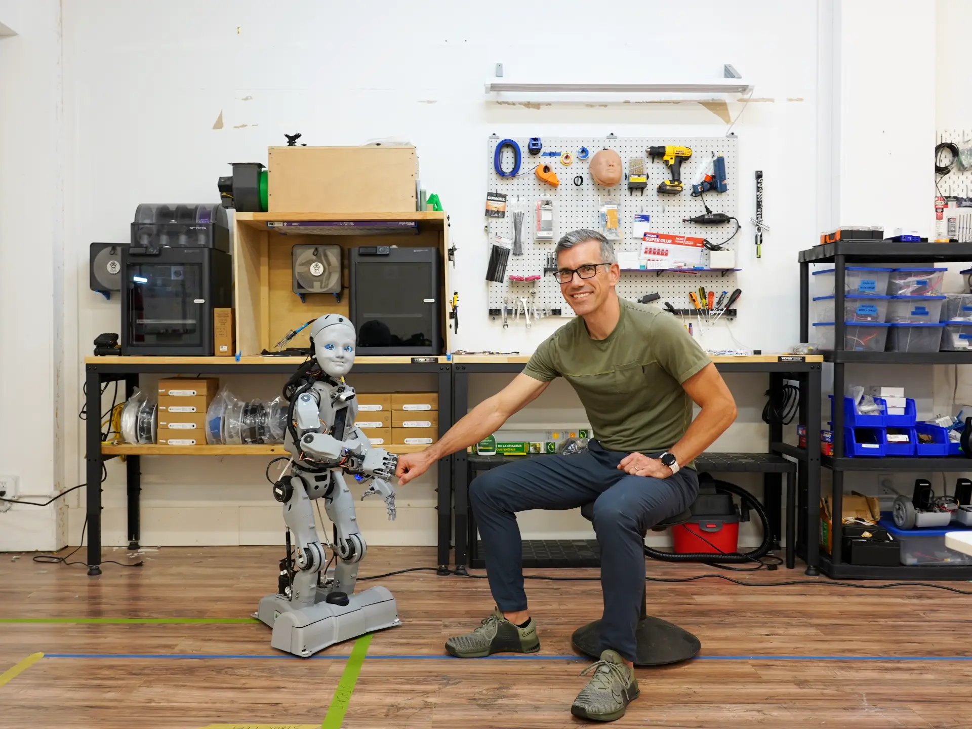 Mind Children engineer fist bumping Codey the robot in the workshop
